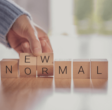 Blocks spelling 'New Normal' being arranged, symbolizing adapting to life changes after a divorce.